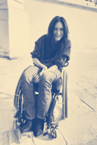A photo of a woman in a wheelchair smiling