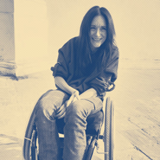 a woman in a wheelchair smiling at the camera